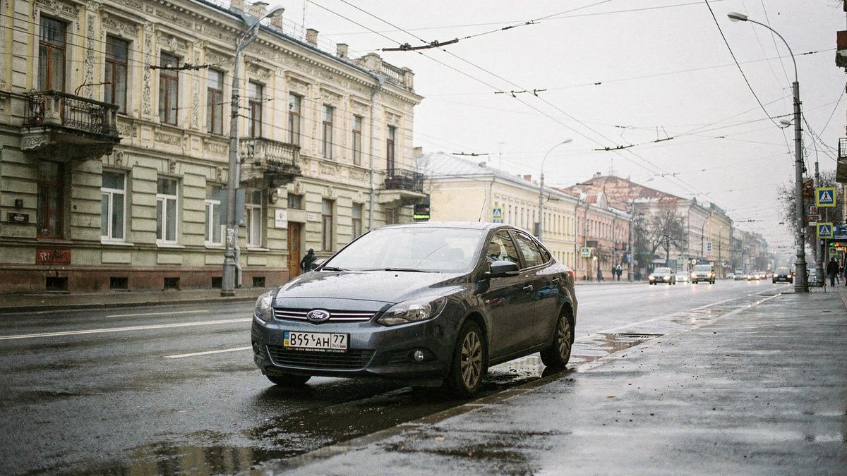 Rental sedan parked at the kerb on a central city street with visible number plate